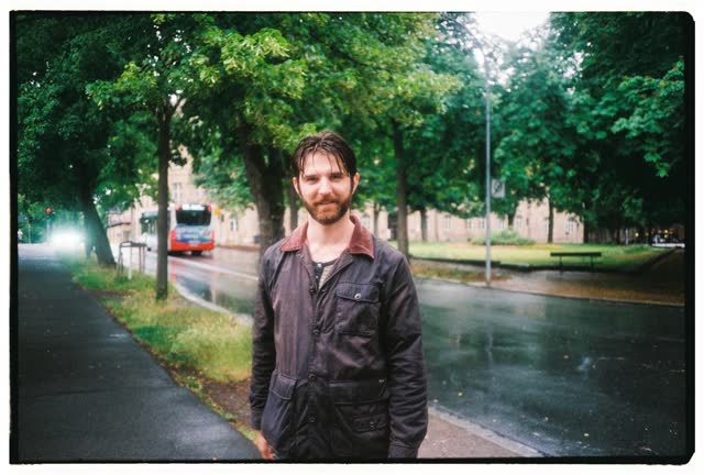 Standing on a tree-lined street after getting caught in the rain