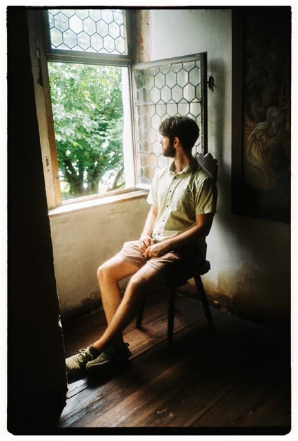 Sitting by an open window with honeycomb glass, looking out at a tree